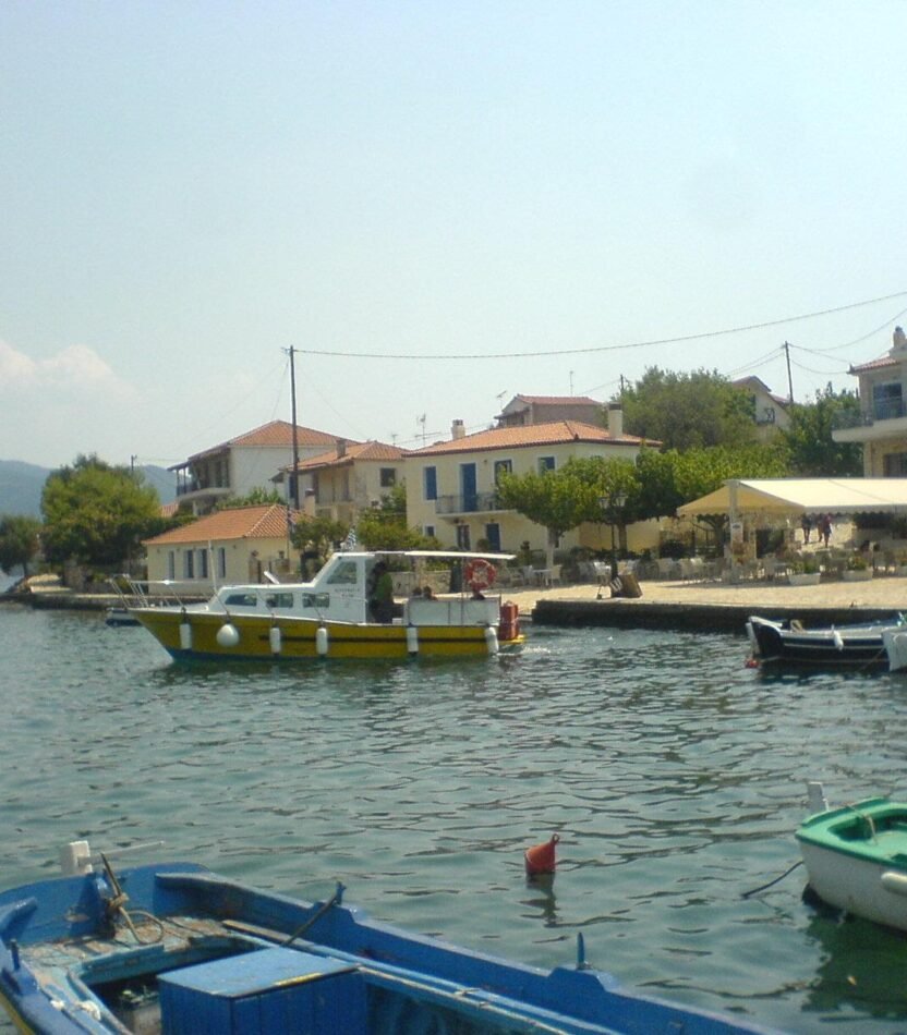 Βάρκες και παραθαλάσσια κτίρια στο λιμανάκι των Τριζονίων