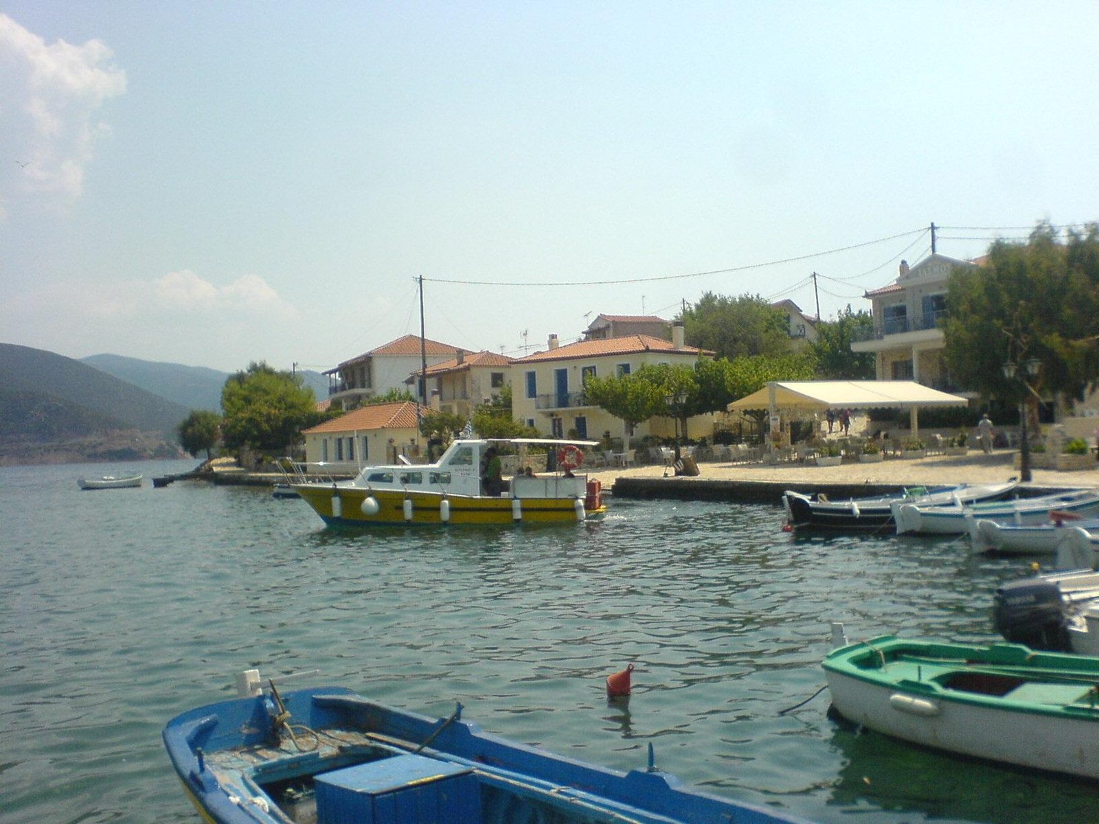 Βάρκες και παραθαλάσσια κτίρια στο λιμανάκι των Τριζονίων